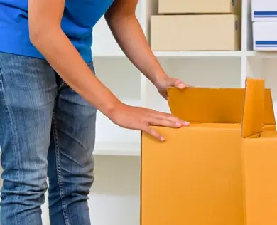 A woman packs a box for a residential move