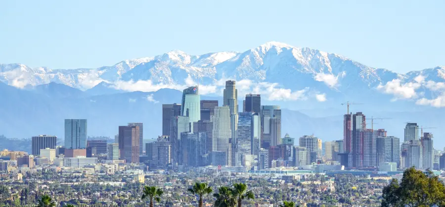 Downtown Los Angeles with a backdrop of snow-capped mountains