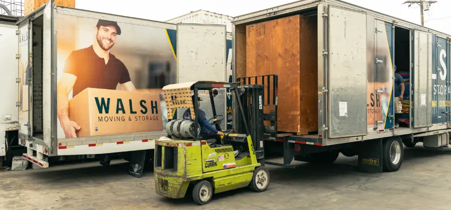 A Walsh worker unloads a vault from a trailer