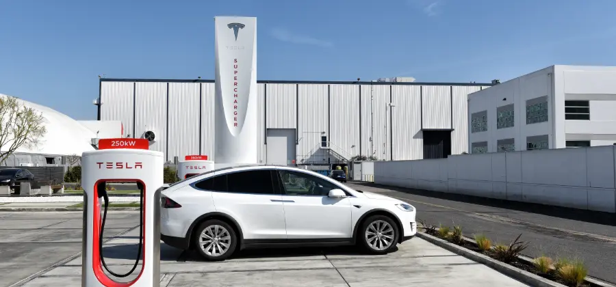 A white Tesla parked at a charging station in Hawthorne